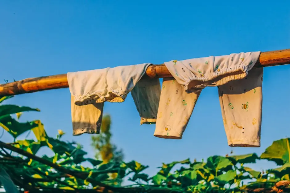 Natural drying techniques with baby clothes on bamboo under clear sky in Bangladesh.