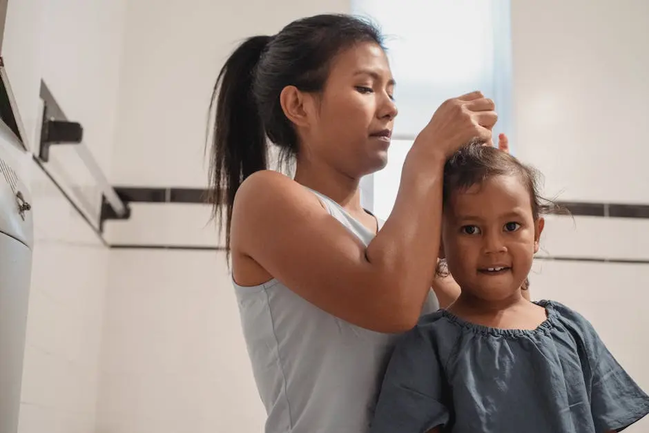 Focused young Hispanic mother in casual outfit braiding hair of cute little daughter looking at camera