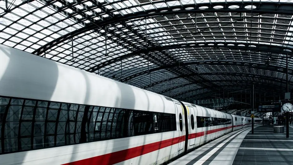 High-speed train at Berlin’s iconic glass-roofed railway station, showcasing urban transport.