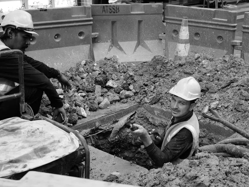Black and white photo of construction workers in a trench at a building site in Kuala Lumpur, Malaysia.