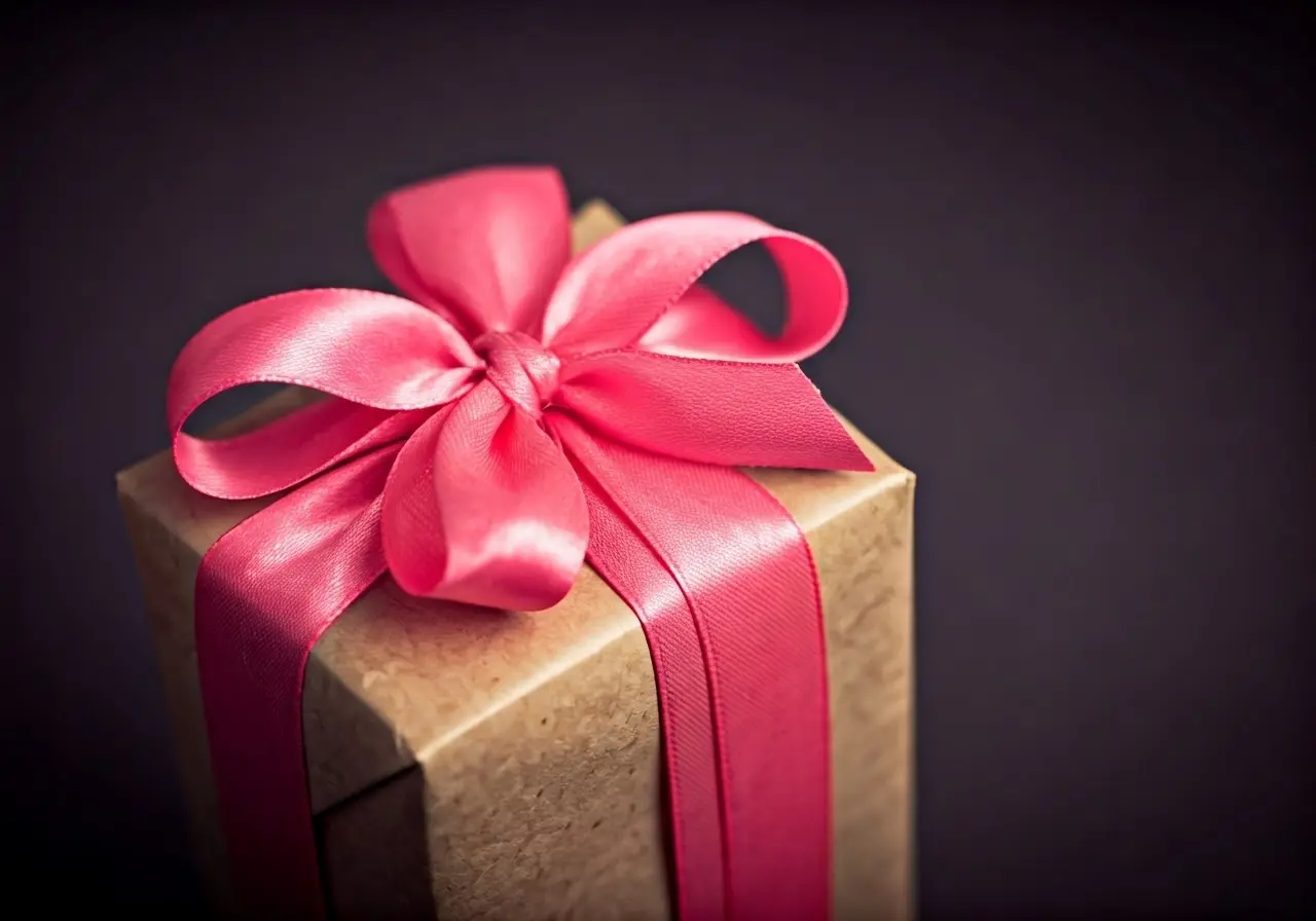 A beautifully wrapped gift with a pink ribbon and bow. 35mm stock photo