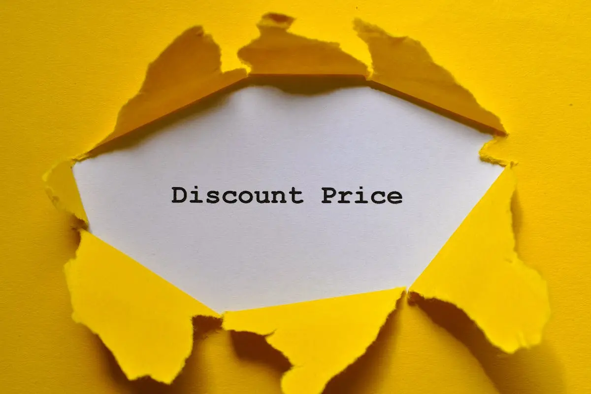 Eye-catching image of torn yellow paper revealing the words ‘Discount Price.’