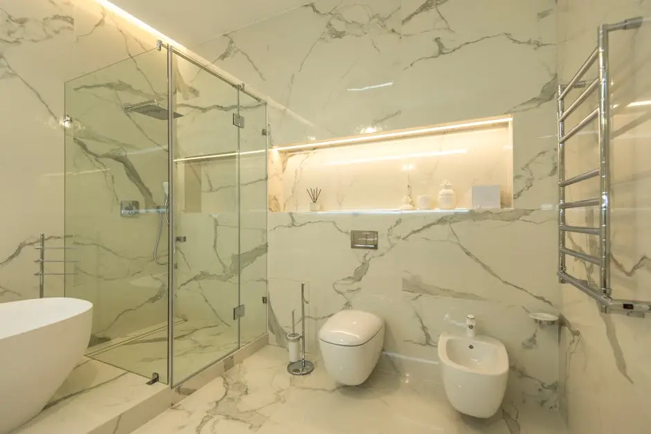 Elegant luxury bathroom featuring marble walls, a glass shower, and modern fixtures.