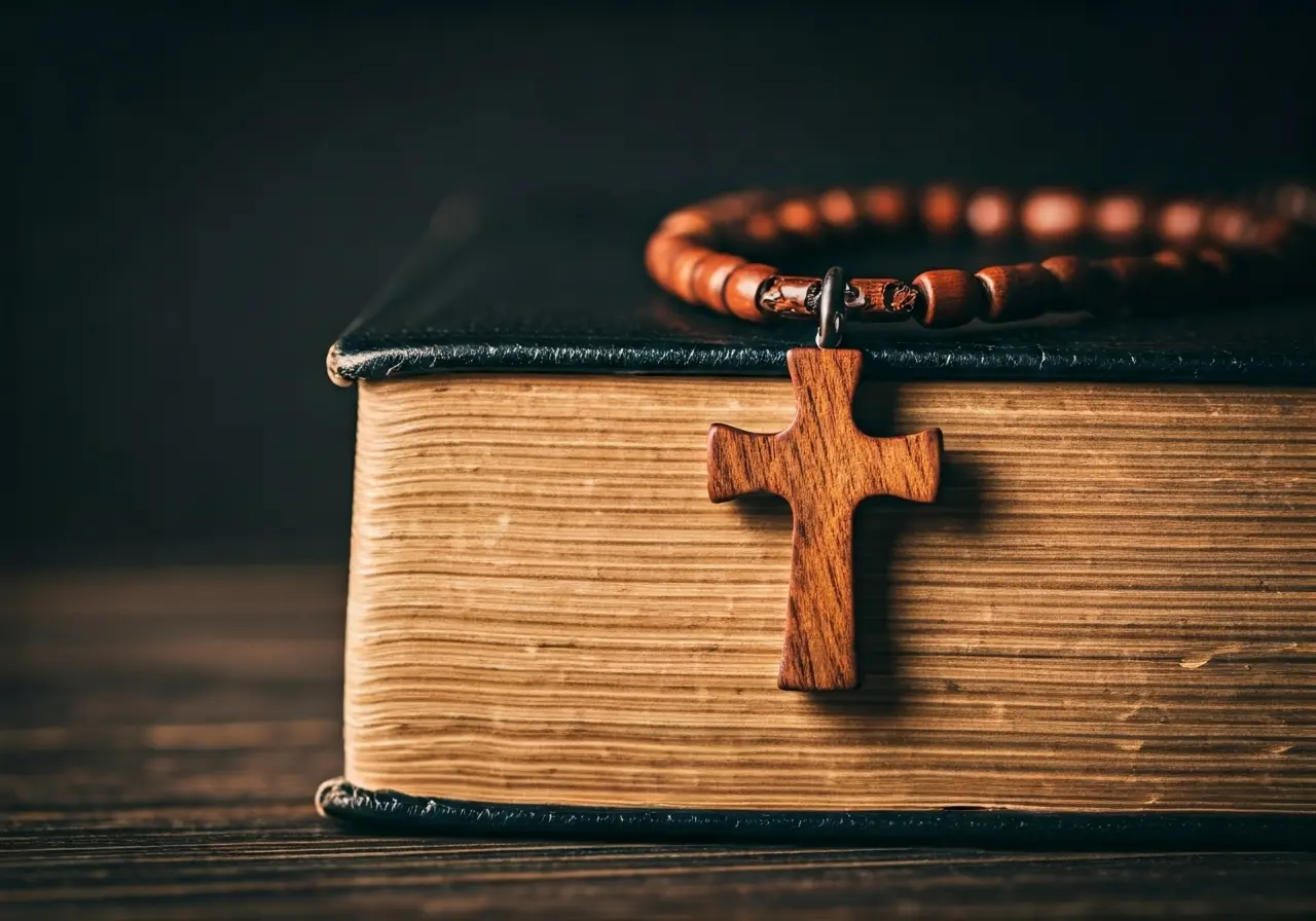 A wooden cross necklace resting on an open Bible. 35mm stock photo