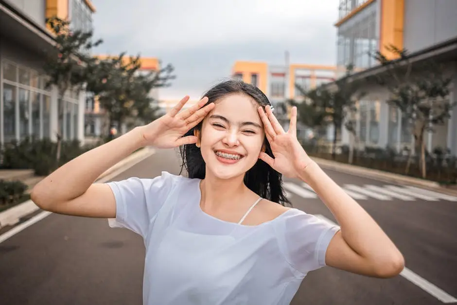 A young woman smiling brightly with braces, enjoying the outdoors.