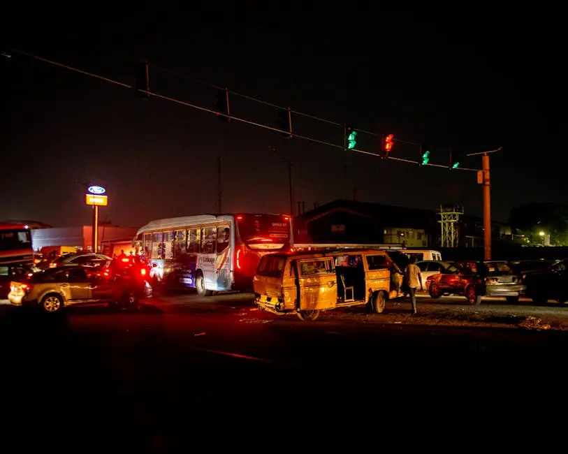 A crowded urban nighttime scene featuring a traffic accident at a busy intersection.